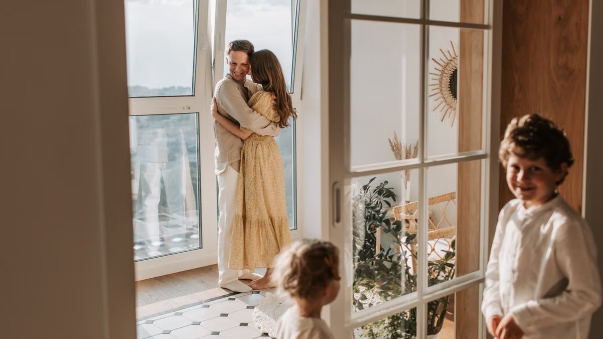 A joyful family moment with parents and children cuddling indoors during the day.